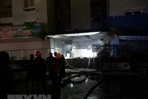 Cảnh sát PCCC phun nước dập tắt đám cháy phát ra từ tầng hầm chung cư. (Ảnh: Thành Chung/TTXVN)