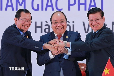 Ba thủ tướng thể hiện tinh thần đoàn kết và hợp tác 3 nước sau khi ký kết Tuyên bố chung Hội nghị Cấp cao hợp tác Khu vực Tam giác phát triển Campuchia-Lào-Việt Nam (CLV) lần thứ 10. (Ảnh: TTXVN)