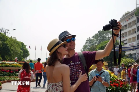 Khách du lịch quốc tế tham quan và chụp ảnh lưu niệm tại Phố đi bộ Nguyễn Huệ, Thành phố Hồ Chí Minh. (Ảnh: Phương Vy/TTXVN)