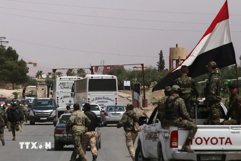 Binh sỹ Syria giám sát việc sơ tán của phiến quân khỏi khu vực Douma ngày 9/4. (Nguồn: AFP/TTXVN)
