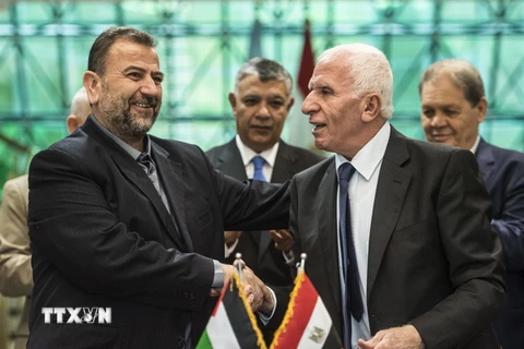 Trưởng đoàn đàm phán của Hamas, ông Saleh al-Aruri (trái) và Trưởng đoàn đàm phán của Fatah, ông Azzam al-Ahmad (phải) sau lễ ký thỏa thuận hòa giải tại Cairo, Ai Cập ngày 12/10/2017. (Nguồn: AFP/TTXVN)