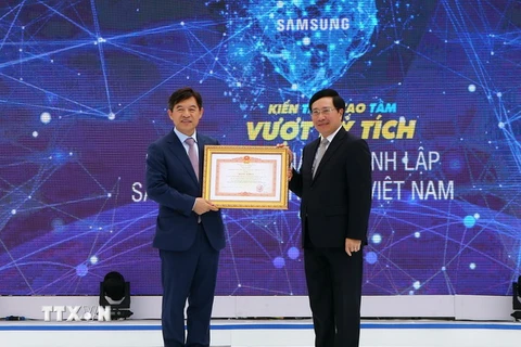Phó Thủ tướng, Bộ trưởng Ngoại giao Phạm Bình Minh đến dự và trao tặng Bằng khen của Thủ tướng Chính phủ cho đại diện Samsung Việt Nam. (Ảnh: Danh Lam/TTXVN)