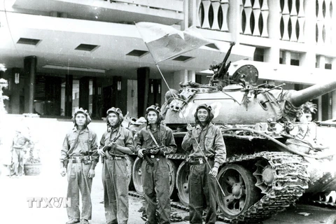 Bốn chiến sỹ Binh đoàn Hương Giang cắm cờ trên nóc Phủ Tổng thống ngụy Sài Gòn ngày 30/4/1975 (Người cầm cờ là chiến sỹ Bùi Quang Thận).