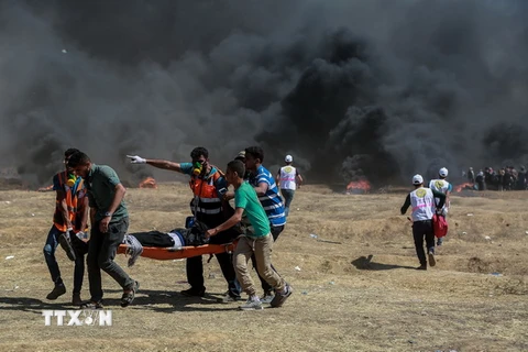 Chuyển người biểu tình Palestine bị thương sau các cuộc đụng độ với binh sỹ Israel tại khu vực biên giới Dải Gaza với Israel ngày 14/5. (Nguồn: THX/TTXVN)