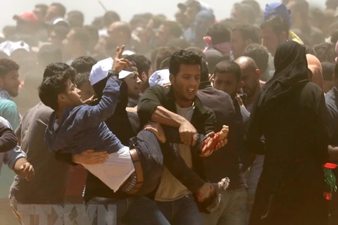 Chuyển người biểu tình Palestine bị thương sau các cuộc đụng độ với binh sỹ Israel tại khu vực biên giới Dải Gaza với Israel ngày 14/5. (Nguồn: AFP/TTXVN)