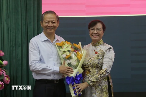 Chủ tịch HĐND Thành phố Hồ Chí Minh Nguyễn Thị Quyết Tâm tặng hoa ông Lê Văn Khoa. (Ảnh: Tiến Lực/TTXVN)