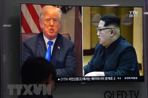 Người dân theo dõi qua truyền hình hình ảnh Tổng thống Mỹ Donald Trump (trái) và Nhà lãnh đạo Triều Tiên Kim Jong-un ngày 24/5 vừa qua. (Ảnh: AFP/TTXVN)