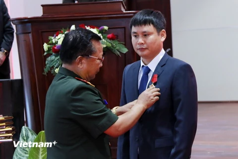 Thượng tướng Chansamone Chanyalath, Ủy viên Bộ Chính trị, Bộ trưởng Quốc phòng Lào đang gắn Huân chương Anh dũng Hạng II cho ông Cao Anh Sơn, Tổng Giám đốc Công ty Star Telecom. (Ảnh: Phạm Kiên/Vietnam+)