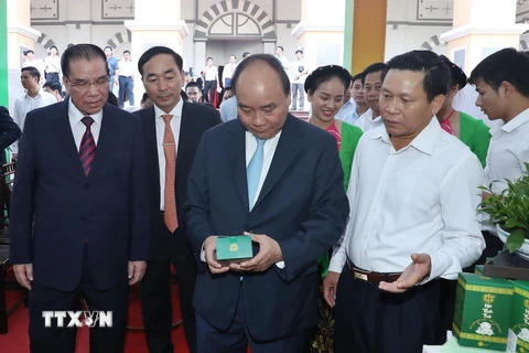Thủ tướng Nguyễn Xuân Phúc và các đại biểu tham quan gian hàng trưng bày các sản phẩm của tỉnh Thái Nguyên tại hội nghị. (Ảnh: Thống Nhất/TTXVN)