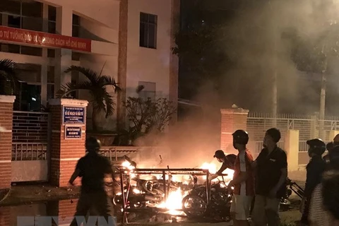 Một số đối tượng quá khích lôi xe máy từ trong Sở Kế hoạch và Đầu tư tỉnh Bình Thuận ra đốt phá ngày 10/6/2018. (Ảnh: Nguyễn Thanh/TTXVN)