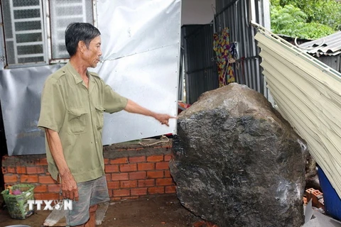 Tảng đá nặng khoảng hơn 3 tấn lăn vào nhà ông Huỳnh Thanh Phong. (Ảnh: Lê Sen/TTXVN)