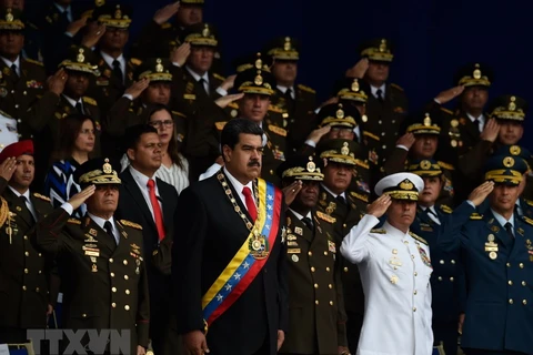 Ngày 4/8, một vụ nổ đã làm gián đoạn Lễ kỷ niệm 81 năm ngày thành lập Lực lượng Phòng vệ quốc gia Venezuela ở thủ đô Caracas. Vụ nổ xảy ra khi Tổng thống Venezuela Nicolas Maduro (giữa) đang phát biểu. (Ảnh: AFP/TTXVN)
