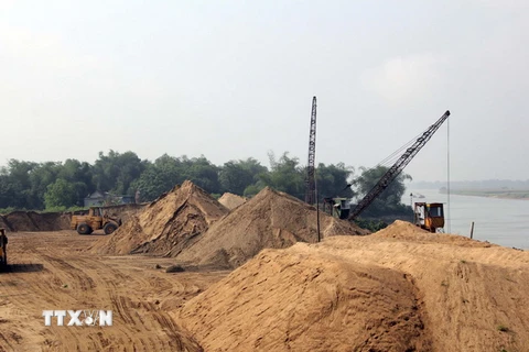 Một bến cát trái phép hoạt động rầm rộ dưới chân cầu đường sắt Yên Xuân, huyện Hưng Nguyên, Nghệ An. (Ảnh: Tá Chuyên/TTXVN)