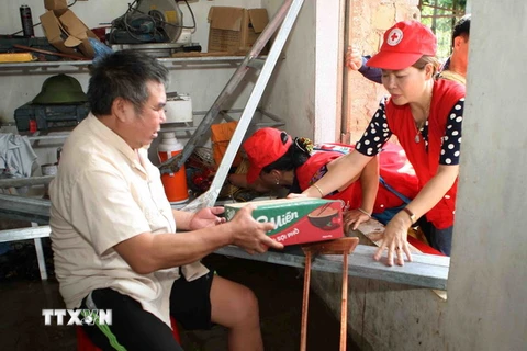 Cán bộ Hội Chữ thập Đỏ thành phố Hà Nội trao quà hỗ trợ người dân xã Tân Tiến, huyện Chương Mỹ, Hà Nội. (Ảnh: Thanh Tùng/TTXVN)