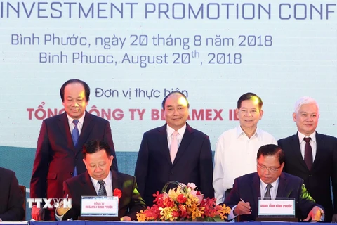 Thủ tướng Nguyễn Xuân Phúc, nguyên Chủ tịch nước Nguyễn Minh Triết chứng kiến lễ ký biên bản thỏa thuận phát triển dự án Khu liên hợp Becamex - Bình Phước. (Ảnh: Thống Nhất/TTXVN)