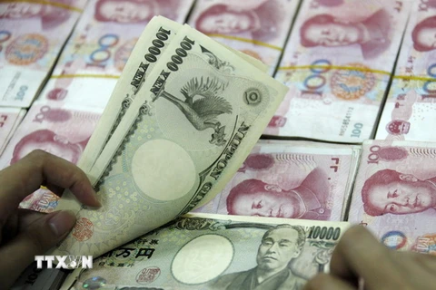 Đồng 10.000 yen Nhật (phía trên) và đồng 100 Nhân dân tệ của Trung Quốc (phía dưới) tại ngân hàng ở Hoài Bắc, tỉnh An Huy, Trung Quốc. (Ảnh: AFP/ TTXVN)