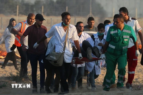 Chuyển người biểu tình Palestine bị thương tại khu vực biên giới Gaza- Israel ngày 3/8. (Ảnh: AFP/TTXVN)