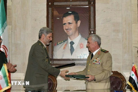 Bộ trưởng Quốc phòng Syria Abdullah Ayoub (phải) trao đổi văn kiện hợp tác với Bộ trưởng Quốc phòng Iran Amir Hatami (trái) đang ở thăm Damascus ngày 26/8. (Ảnh: AFP/TTXVN)