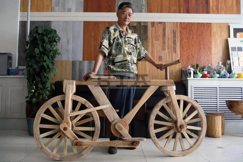 Ông He Yong bên chiếc xe đạp gỗ. (Nguồn: bta.bg)