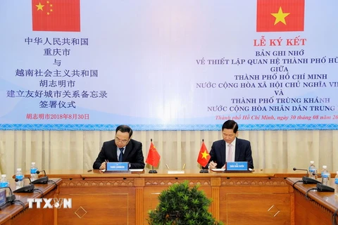 Ông Trần Vĩnh Tuyến và ông Tang Liangzhi ký Biên bản thỏa thuận thiết lập quan hệ thành phố hữu nghị. (Ảnh: Xuân Khu/TTXVN)