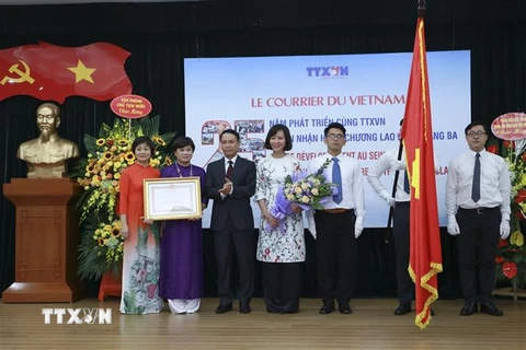 Tổng Giám đốc Nguyễn Đức Lợi trao Huân chương Lao động hạng 3 cho tập thể báo Le Courrier du Vietnam. (Ảnh: TTXVN)