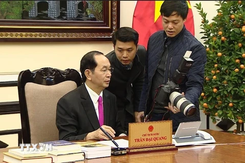 Chủ tịch nước Trần Đại Quang xem lại các bức hình chụp cho ông dịp Xuân Mậu Tuất 2018 vừa qua. (Ảnh: TTXVN)