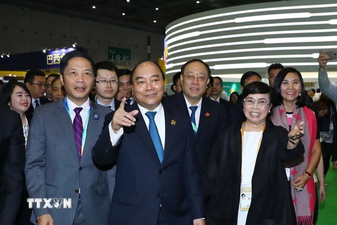 Thủ tướng Nguyễn Xuân Phúc thăm Khu gian hàng thương mại của các doanh nghiệp Việt Nam. (Ảnh: Thống Nhất/TTXVN)