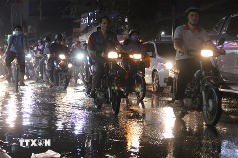 Nước ngập do triều cường dâng cao tại đường Huỳnh Tấn Phát khiến giao thông khó khăn. (Ảnh: Xuân Dự/ TTXVN)