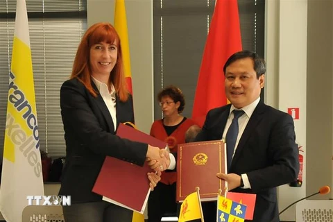 Thứ trưởng Bộ Kế hoạch và Đầu tư Vũ Đại Thắng và Tổng Giám đốc Cơ quan ngoại giao Wallonie-Bruxelles, Pascale Delcomminette trao biên bản hợp tác được ký kết. (Ảnh: Kim Chung/ TTXVN)