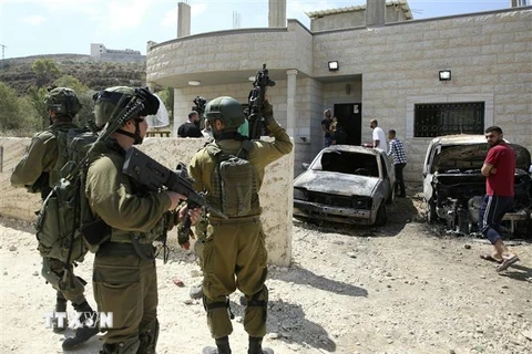 Binh sỹ Israel gác tại hiện trường một vụ tấn công gần Nablus, Bờ Tây ngày 13/7. (Ảnh: AFP/TTXVN)