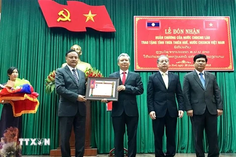 Ông Santyphap Phomvyhan, Ủy viên Ban Chấp hành Trung ương Đảng Nhân dân Cách mạng Lào, thừa ủy quyền trao tặng Huân chương Lao động hạng Nhất cho tỉnh Thừa Thiên-Huế. (Ảnh: Mai Trang/TTXVN)