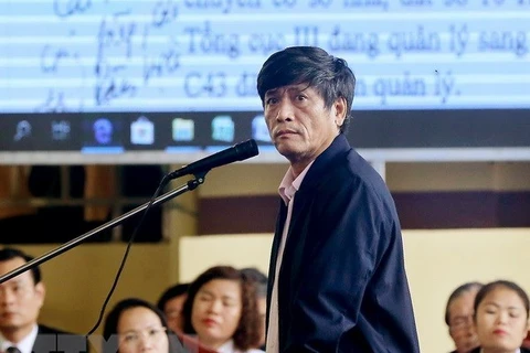 Bị cáo Nguyễn Thanh Hóa xem các văn bản là tang vật của vụ án được chiếu trên màn hình. (Ảnh: Trung Kiên/TTXVN)