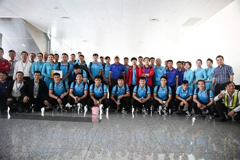 Đội tuyển Việt Nam chụp ảnh lưu niệm với nhân viên mặt đất Vietnam Airlines tại sân bay Nội Bài ngày 7/12. (Ảnh: Hoàng Linh/TTXVN)