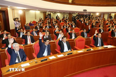 Đại biểu biểu quyết thông qua dự thảo Nghị quyết hội nghị lần thứ chín, Ban chấp hành Trung ương Đảng khóa XII. (Ảnh: Trí Dũng/TTXVN)