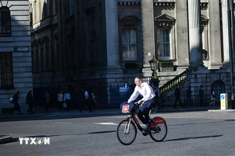 Người dân sử dụng xe đạp tại London, Anh. (Nguồn: AFP/TTXVN)