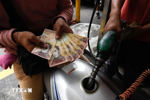Người dân dùng đồng Bolivar để thanh toán tiền xăng tại Caracas, Venezuela, ngày 14/8/2018. (Ảnh: AFP/ TTXVN)