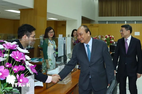 Thủ tướng Nguyễn Xuân Phúc đến thăm, chúc Tết cán bộ, viên chức, người lao động Ngân hàng Chính sách xã hội trong ngày làm việc đầu tiên của Xuân Kỷ Hợi 2019. (Ảnh: Thống Nhất/TTXVN)