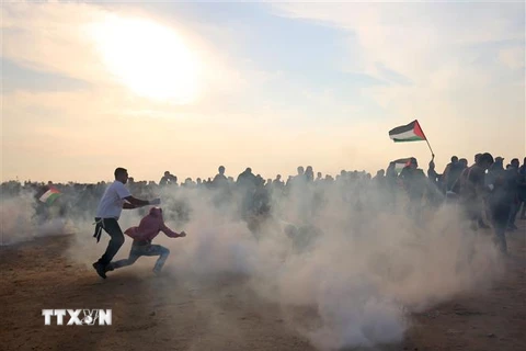 Người biểu tình Palestine chạy trốn đạn hơi cay trong cuộc xung đột với binh sỹ Israel tại thành phố biên giới Khan Yunis, phía nam Dải Gaza ngày 9/11/2018. (Ảnh: AFP/ TTXVN)