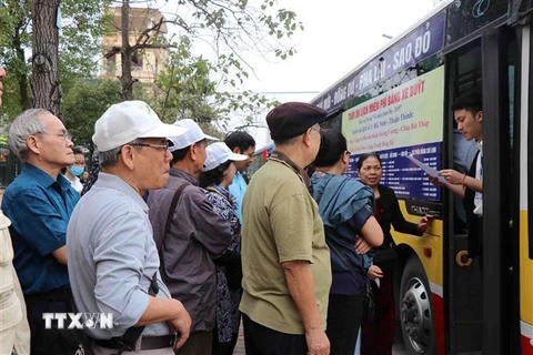 Du khách xếp hàng lên xe buýt du lịch miễn phí tại điểm đón thành phố Bắc Ninh. (Ảnh: Diệp Trương/TTXVN)