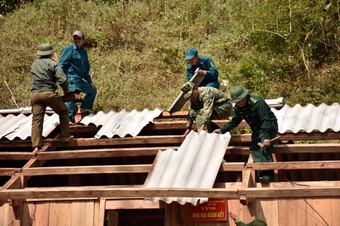Cán bộ, chiến sỹ đồn biên phòng cửa khẩu Lóng Sập giúp người dân sửa lại nhà. (Ảnh minh họa: Hữu Quyết/TTXVN)
