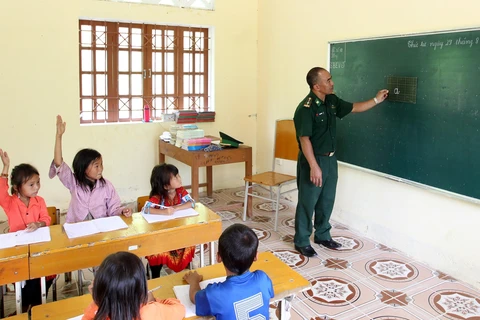 Thầy giáo quân hàm xanh thuộc đồn biên phòng A Mú Sung, huyện Bát Xát, Lào Cai dạy học cho các em học sinh tại điểm trường Phù Lao Chải. (Ảnh minh họa: Quốc Khánh/TTXVN)