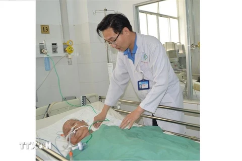 Bác sỹ thăm khám Bà mẹ Việt Nam anh hùng Đinh Thị Thà sau phẫu thuật. (Ảnh: TTXVN phát)