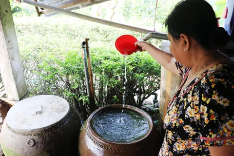 Người dân một số xã trên địa bàn huyện Tân Phước (Tiền Giang) sử dụng thuốc làm sạch nước để sinh hoạt hàng ngày. (Ảnh: Nam Thái/TTXVN)