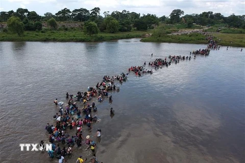 Người di cư vượt sông Suchiate để tới Mexico, trong hành trình tới Mỹ ngày 2/11/2018. (Ảnh: AFP/ TTXVN)