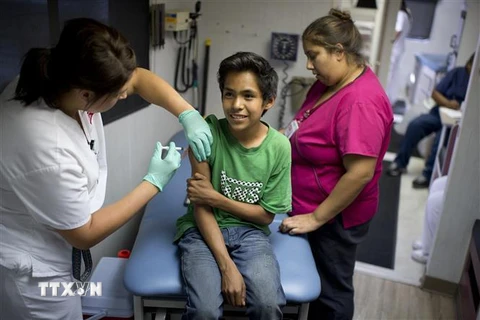 Tiêm vắc xin phòng sởi, quai bị, rubella cho học sinh trước khi bắt đầu năm học mới tại Lynwood, California, Mỹ, ngày 27/8/2013. (Ảnh: AFP/ TTXVN)