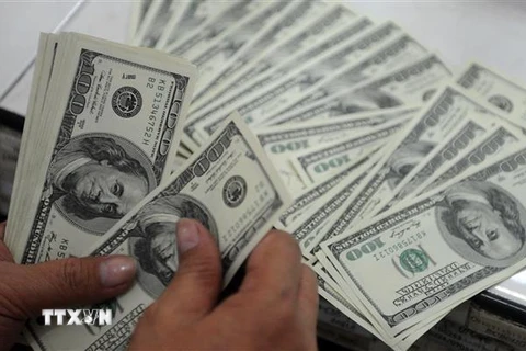 Kiểm tiền USD tại quầy giao dịch tiền tệ ở Manila, Philippines. (Ảnh: AFP/ TTXVN)