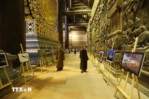 Các đại biểu tham quan Triển lãm ảnh văn hóa Phật giáo tại Điện Tam Thế. (Ảnh: Dương Giang/TTXVN)