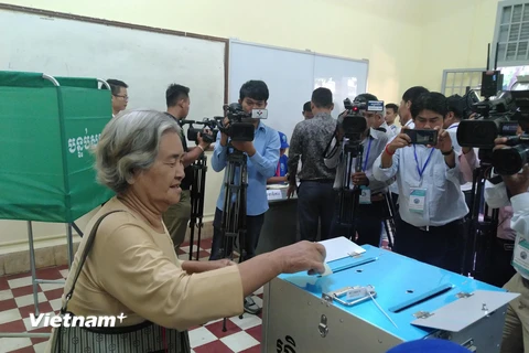 Các cử tri bỏ phiếu bầu vào thùng phiếu tại phòng phiếu số 13 ở thủ đô Phnom Penh. (Nguồn: Vietnam+)