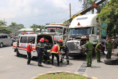 Công an Tây Ninh di chuyển các nạn nhân của vụ tai nạn. (Ảnh: Lê Đức Hoảnh/TTXVN)