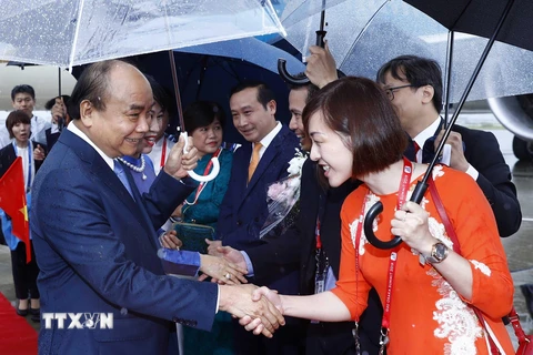 Đại diện cộng đồng người Việt Nam tại Osaka đón Thủ tướng Chính phủ Nguyễn Xuân Phúc và Phu nhân tại sân bay quốc tế Kansai. (Ảnh: Thống Nhất/TTXVN)